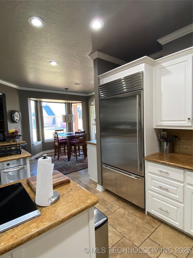 kitchen featuring pendant lighting, white cabinetry, crown molding, and appliances with stainless steel finishes