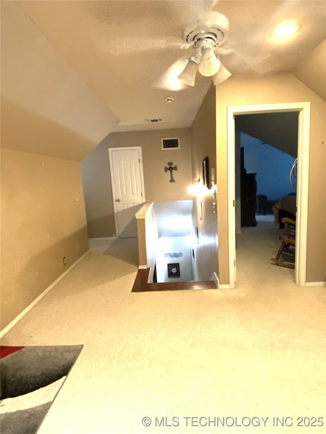 additional living space featuring carpet, ceiling fan, and vaulted ceiling