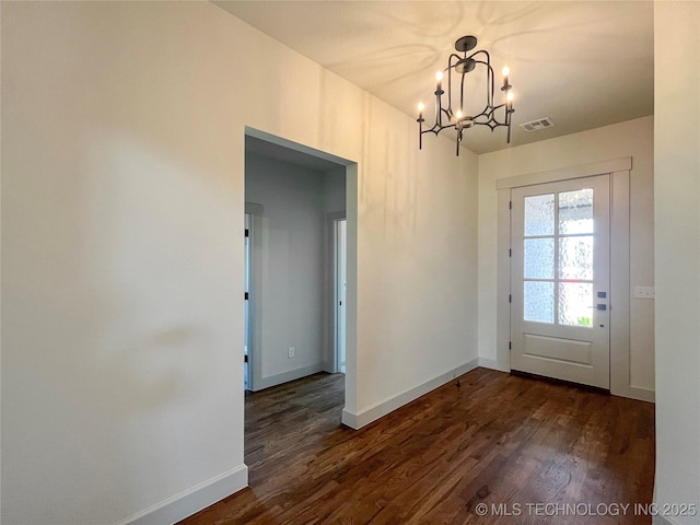 doorway to outside featuring a chandelier and dark hardwood / wood-style floors