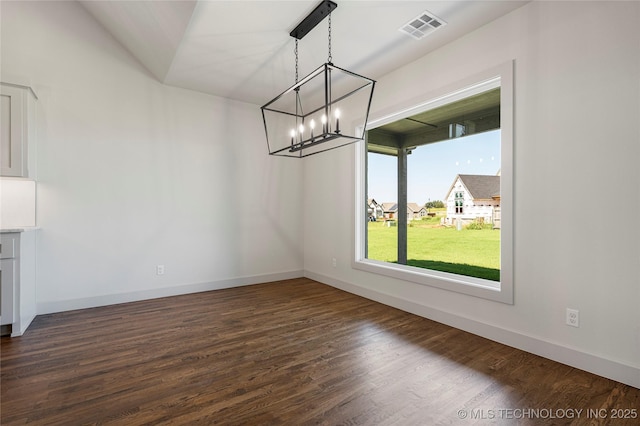 unfurnished dining area featuring vaulted ceiling, an inviting chandelier, and dark wood-type flooring