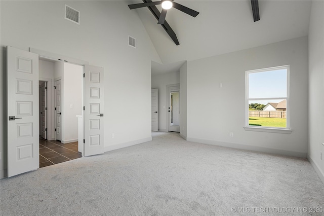 unfurnished bedroom featuring dark colored carpet, ceiling fan, beam ceiling, and high vaulted ceiling