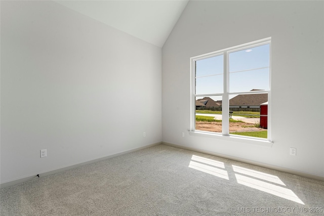 empty room featuring carpet and vaulted ceiling