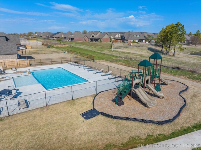 view of pool featuring a playground and a yard