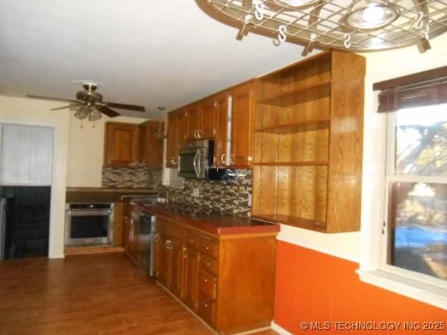 kitchen with appliances with stainless steel finishes, tasteful backsplash, ceiling fan, sink, and hardwood / wood-style floors