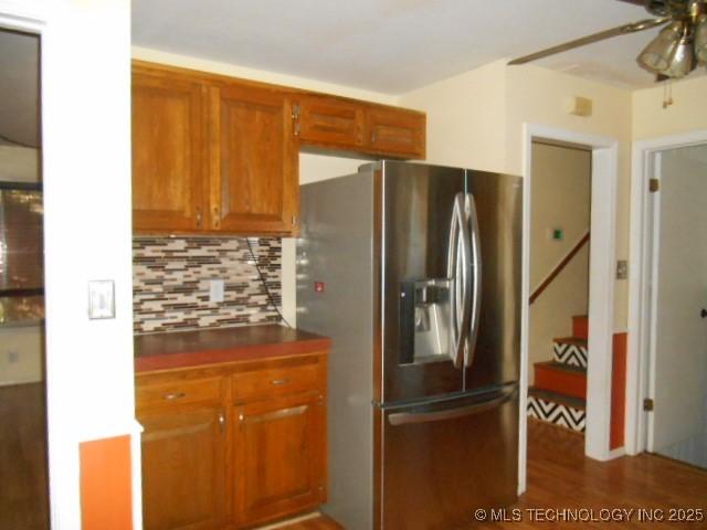 kitchen featuring tasteful backsplash, stainless steel fridge, ceiling fan, and hardwood / wood-style flooring