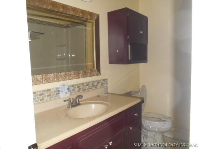 bathroom with a shower, decorative backsplash, vanity, and toilet