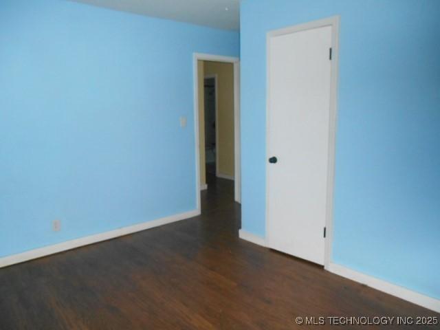 unfurnished room with dark hardwood / wood-style flooring