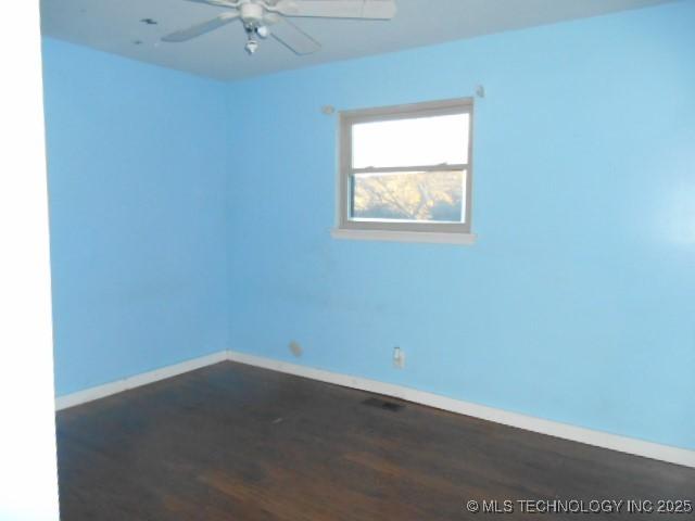 spare room featuring ceiling fan and dark hardwood / wood-style floors