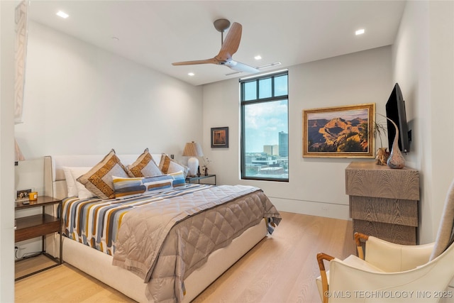 bedroom with ceiling fan and light hardwood / wood-style floors