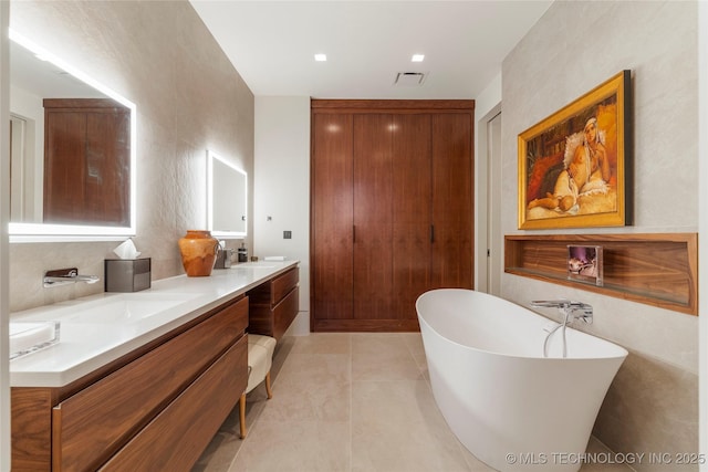 bathroom featuring tile patterned flooring, vanity, and a tub