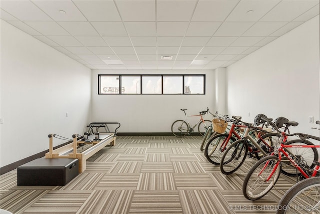 miscellaneous room with a paneled ceiling and light carpet