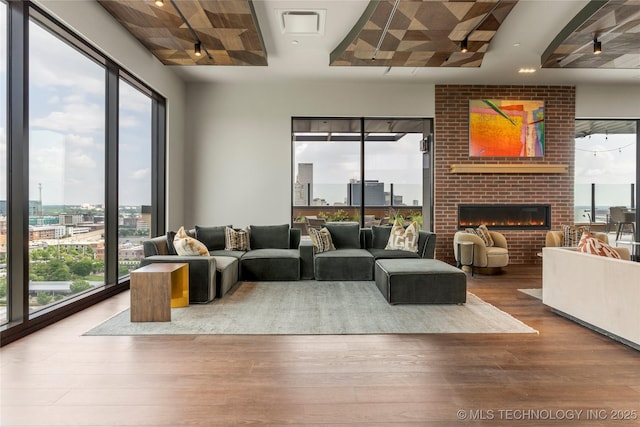 living room with wood-type flooring and a brick fireplace