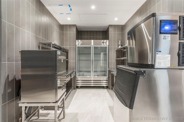 kitchen with refrigerator, stainless steel refrigerator, and tile walls