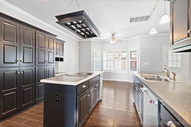 kitchen with pendant lighting, stainless steel dishwasher, ceiling fan, ornamental molding, and an island with sink