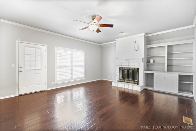 unfurnished living room with a tiled fireplace, ceiling fan, dark hardwood / wood-style flooring, and ornamental molding