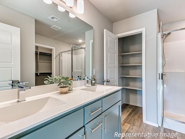 bathroom with vanity, hardwood / wood-style flooring, and an enclosed shower