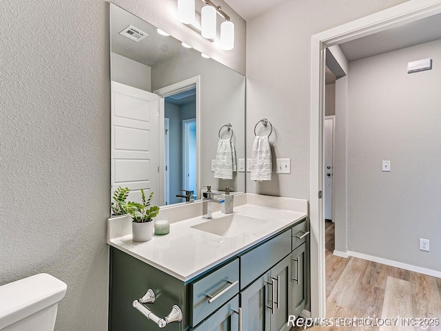 bathroom with vanity, hardwood / wood-style flooring, and toilet