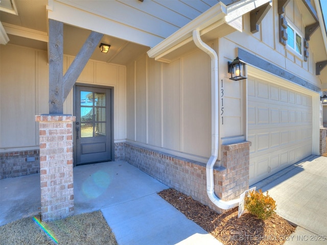 entrance to property with brick siding and a garage