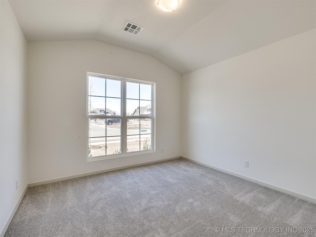 unfurnished room with visible vents, carpet flooring, baseboards, and vaulted ceiling