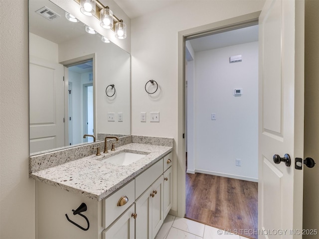 bathroom featuring vanity, baseboards, and visible vents