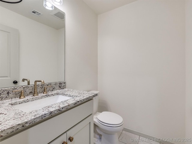 half bath with vanity, toilet, baseboards, and visible vents