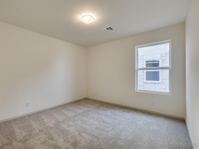 spare room with visible vents, carpet flooring, and baseboards