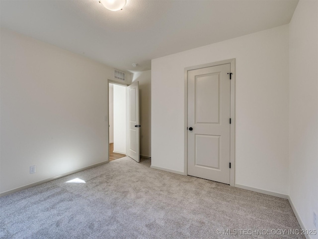 unfurnished bedroom with baseboards, visible vents, and carpet floors