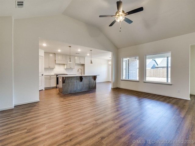 unfurnished living room with visible vents, high vaulted ceiling, a ceiling fan, a sink, and dark wood-style flooring