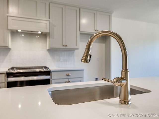 interior details with stainless steel electric stove, light countertops, and a sink