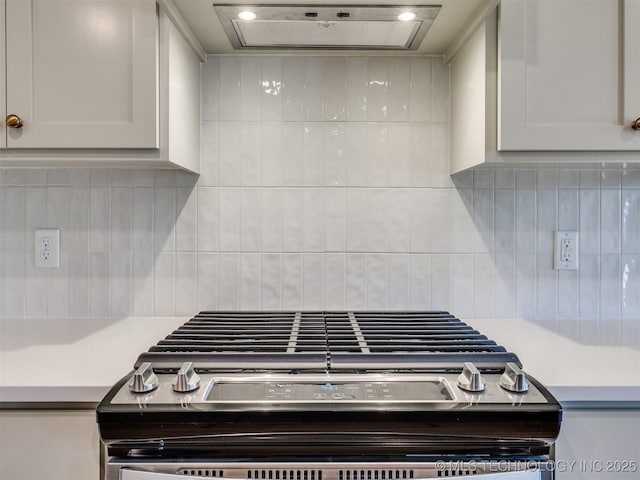 room details with backsplash, white cabinetry, ventilation hood, light countertops, and gas range