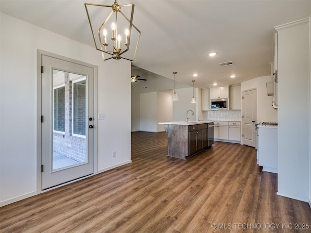 kitchen with visible vents, a kitchen island with sink, dark wood-style flooring, appliances with stainless steel finishes, and open floor plan