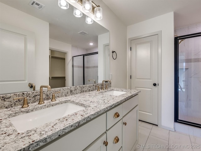 bathroom featuring visible vents, a stall shower, and a sink