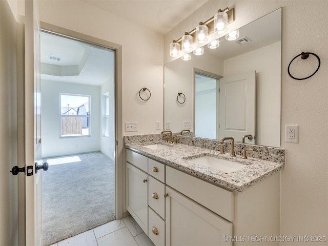 bathroom featuring double vanity, visible vents, and a sink