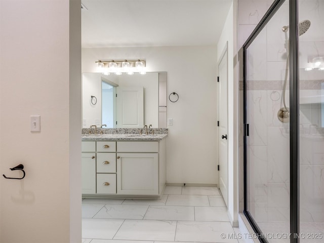 bathroom featuring baseboards, double vanity, a sink, a shower stall, and marble finish floor