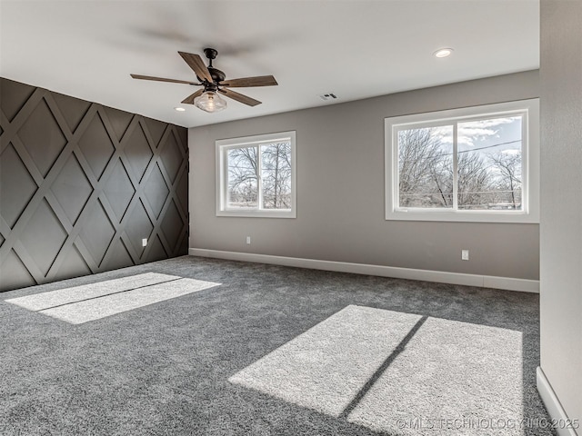 carpeted spare room featuring ceiling fan