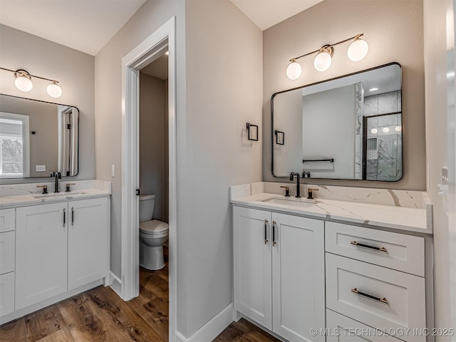 bathroom featuring wood-type flooring, toilet, and vanity