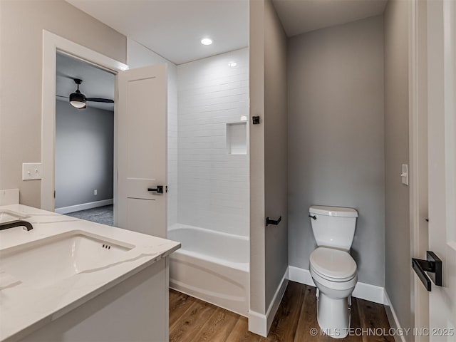 full bathroom featuring hardwood / wood-style flooring, vanity, toilet, and  shower combination