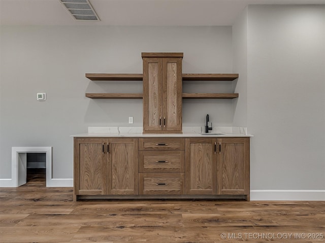 bar featuring dark hardwood / wood-style flooring and sink