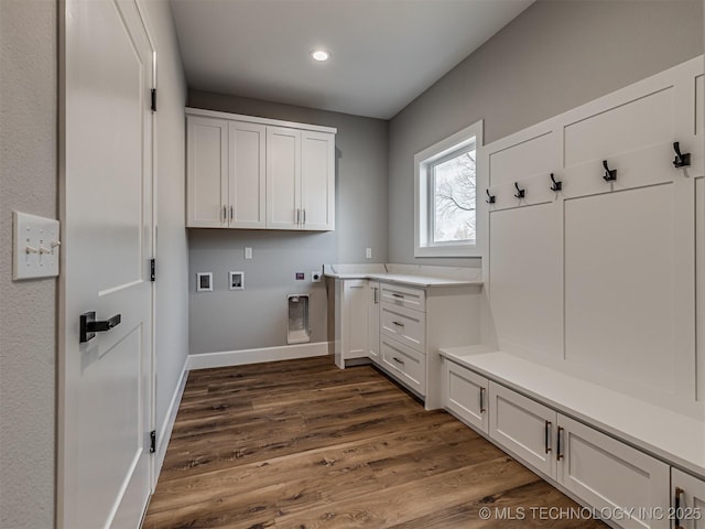 clothes washing area featuring cabinets, hookup for a washing machine, dark hardwood / wood-style floors, and electric dryer hookup