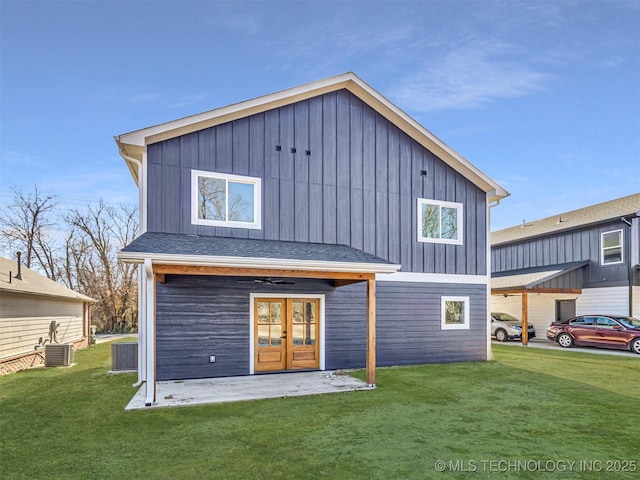 back of property featuring a lawn, central air condition unit, and french doors