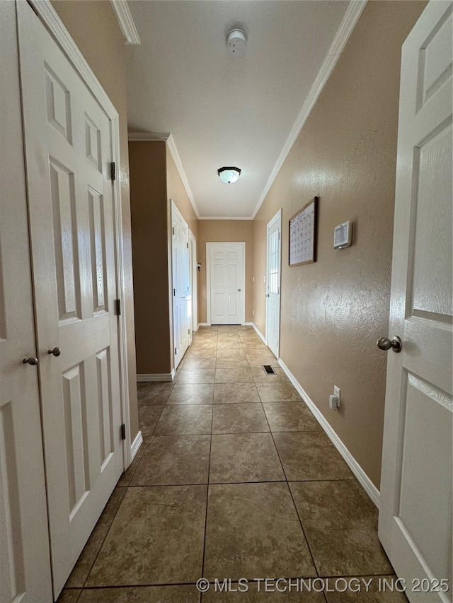 hall with tile patterned flooring and ornamental molding