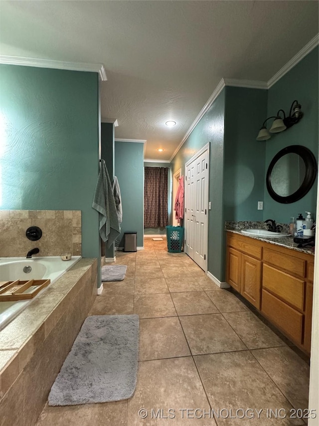 bathroom with tile patterned floors, vanity, ornamental molding, and tiled bath