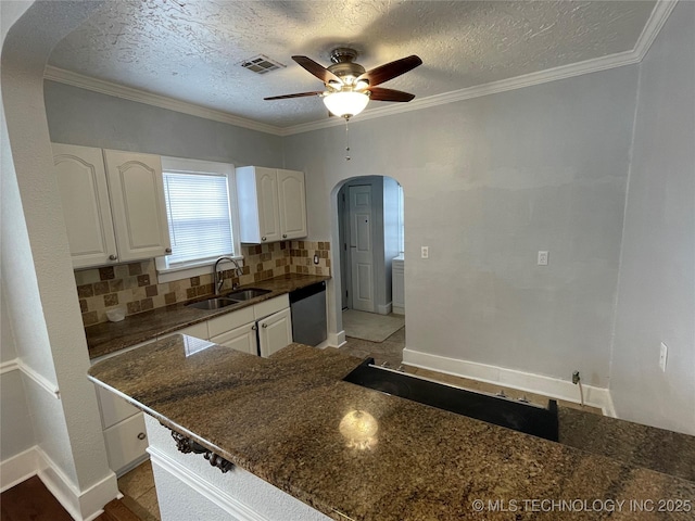 kitchen with tasteful backsplash, white cabinetry, sink, and a textured ceiling