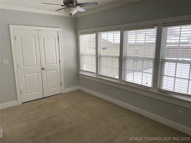 unfurnished bedroom with carpet flooring, ceiling fan, ornamental molding, and a closet