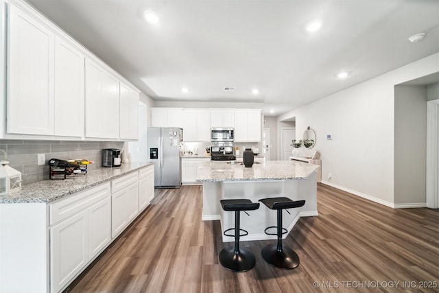 kitchen with a kitchen island, dark hardwood / wood-style flooring, white cabinetry, and stainless steel appliances