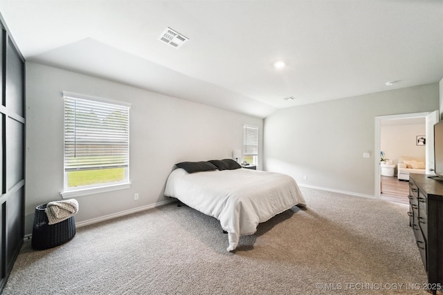 carpeted bedroom with lofted ceiling