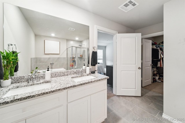 bathroom with tile patterned floors, vanity, and walk in shower