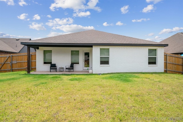 back of house with a patio and a lawn