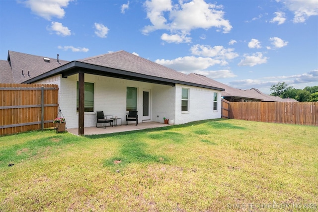 rear view of house featuring a yard and a patio