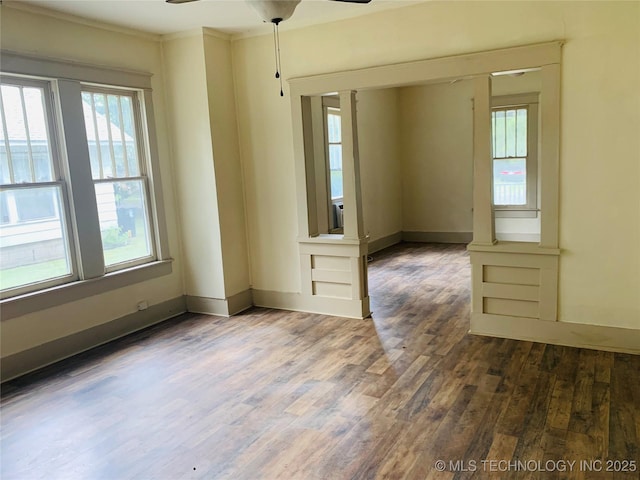 spare room featuring ceiling fan, crown molding, and dark wood-type flooring